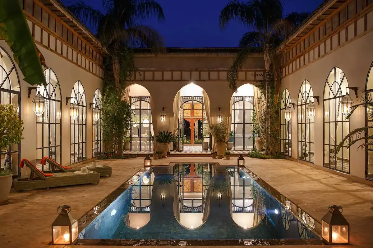 The Daba Village courtyard at night, lit by lanterns around the reflecting pool